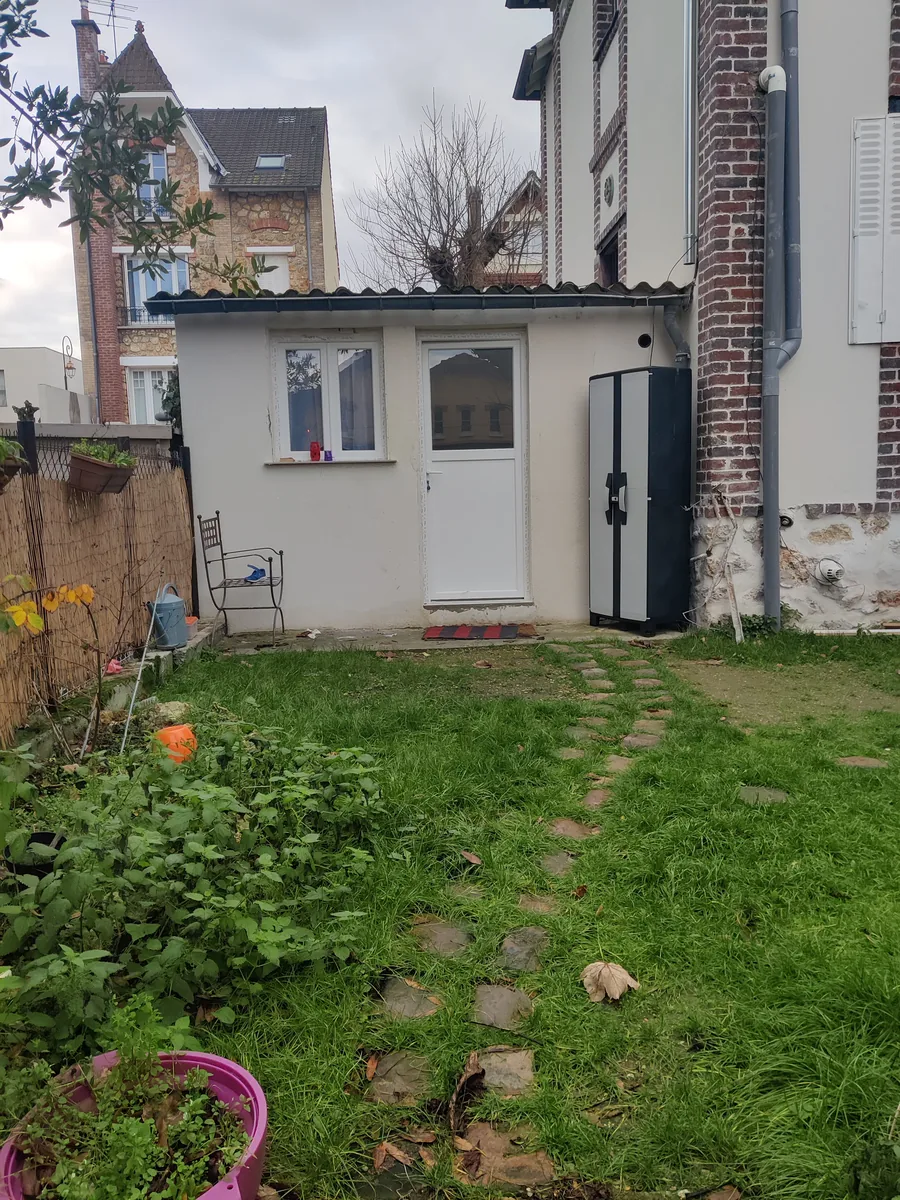 La dépendance transformée, façade enduite et porte neuve, jardin aménagé