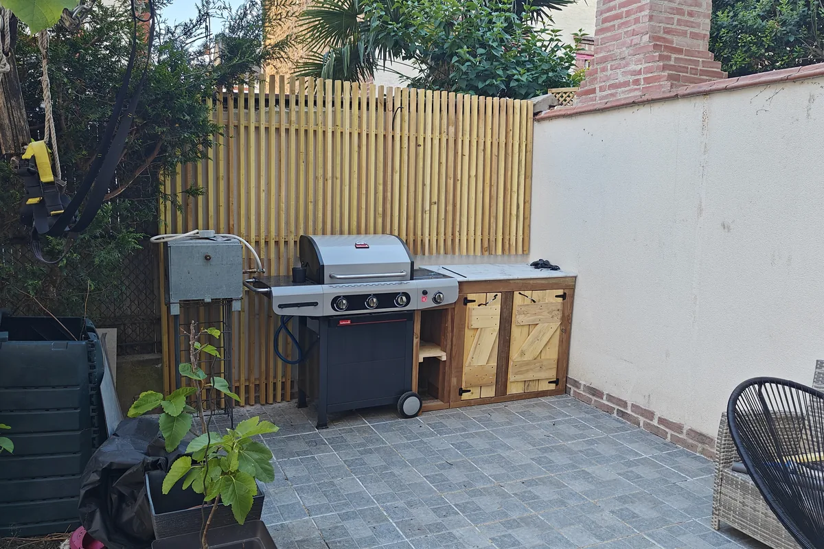 Terrasse aménagée avec claustra bois et espace repas