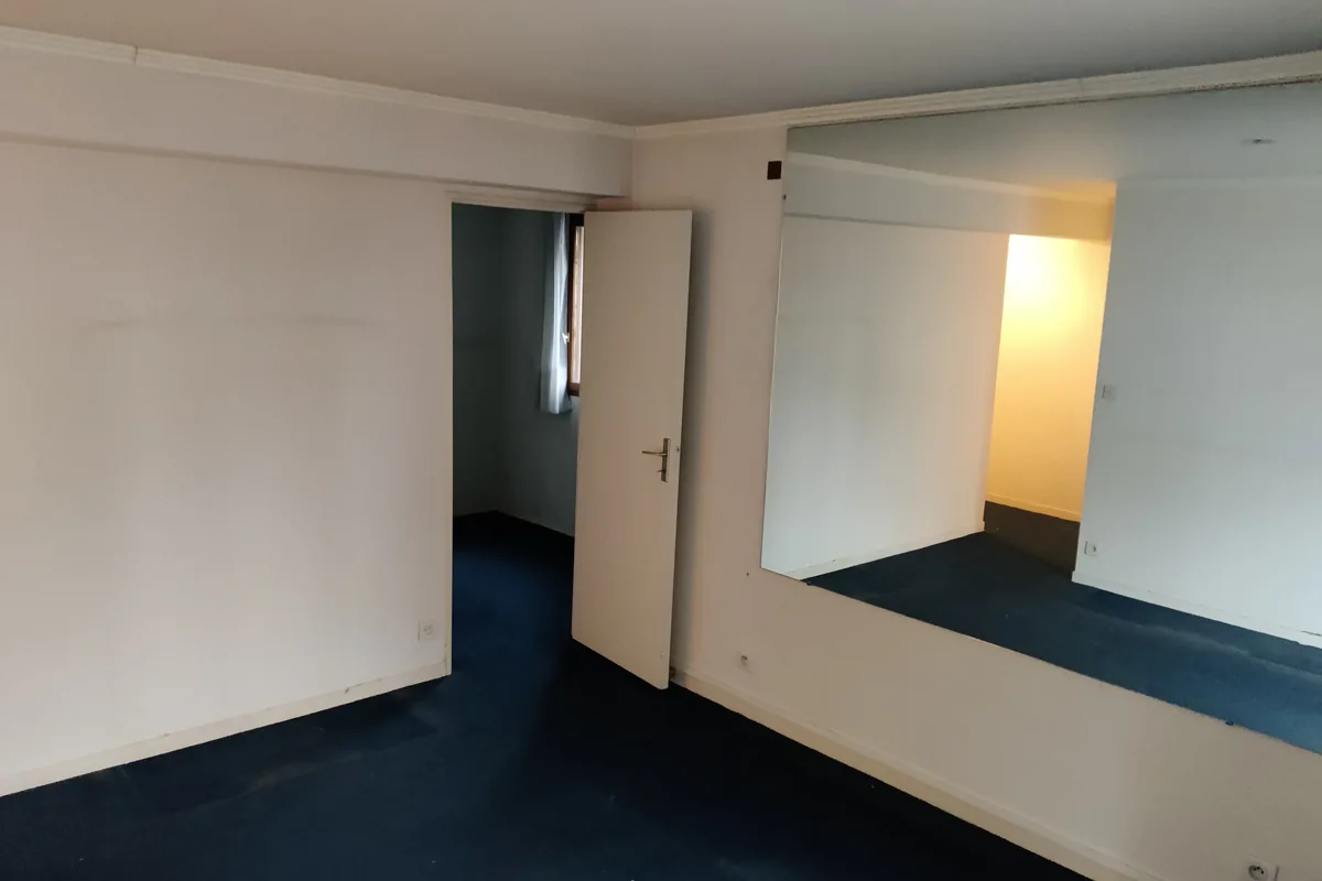 Enfilade des pièces avant travaux, moquette bleue et cloison à déposer