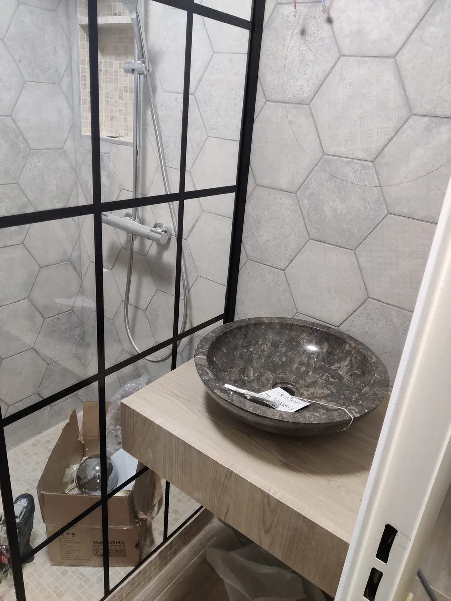 Douche à l'italienne finie, verrière noire et vasque en pierre sur plan bois