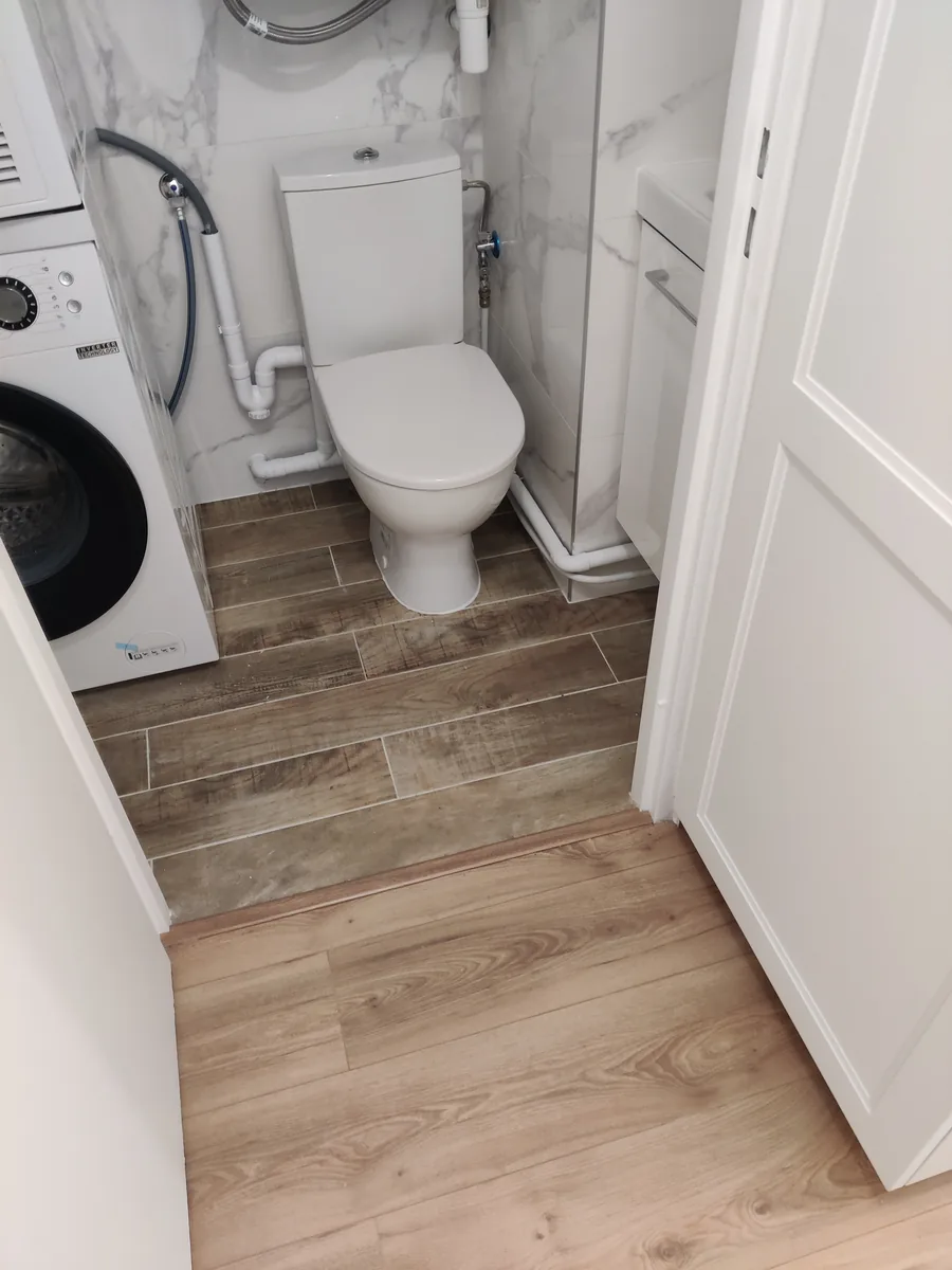 Salle d’eau avec lave-linge intégré et sol effet bois