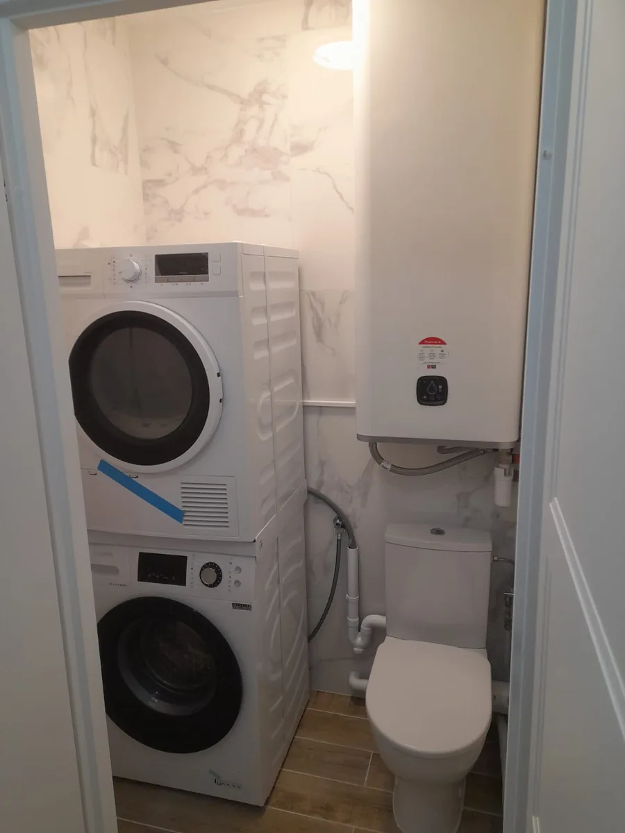 Salle d'eau finie, faïence effet marbre et lave-linge colonne