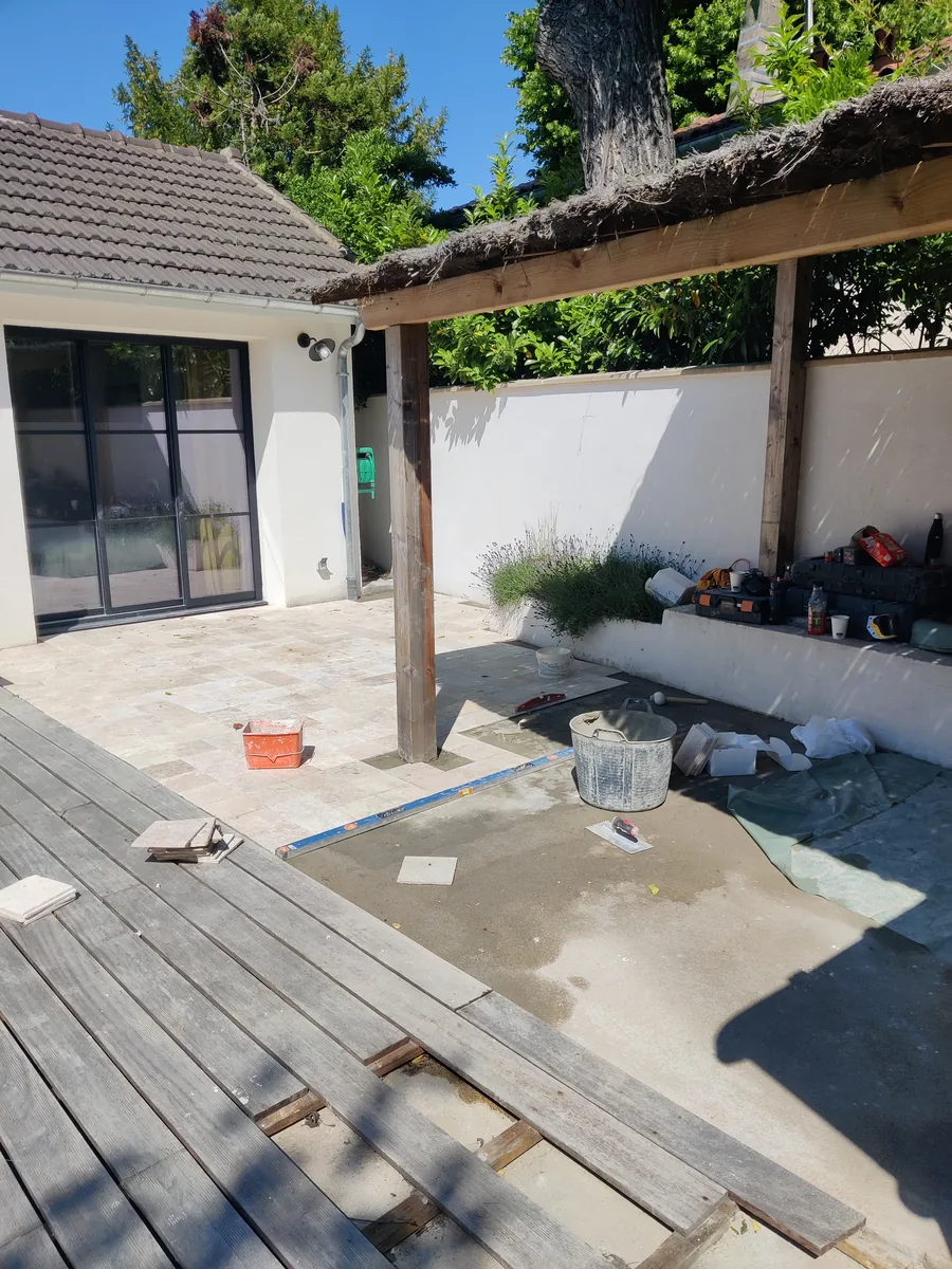 Terrasse en bois protégée par une bâche pendant les travaux d’aménagement extérieur