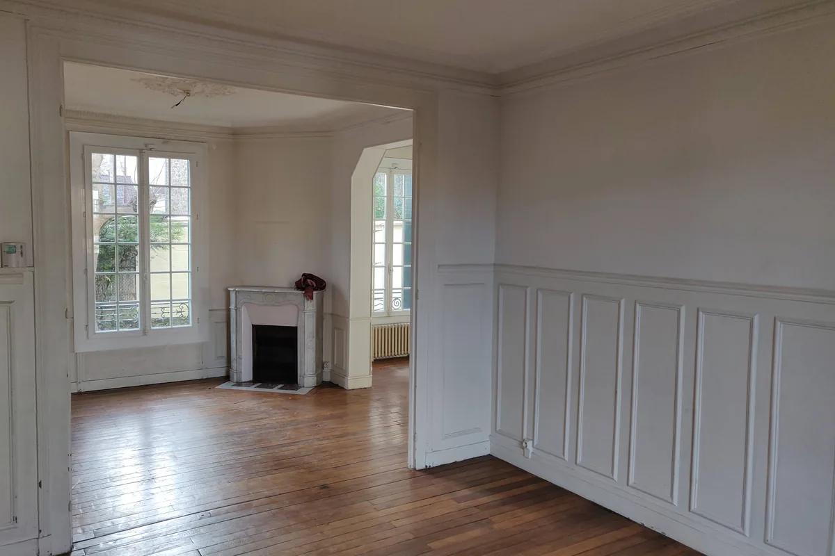 Le salon avant travaux : pièce vide, parquet d’origine, soubassement à repeindre