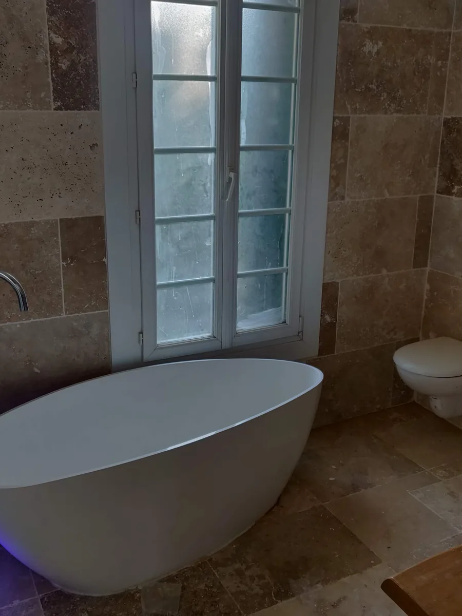 Seconde salle de bain, en travertin, avec baignoire îlot
