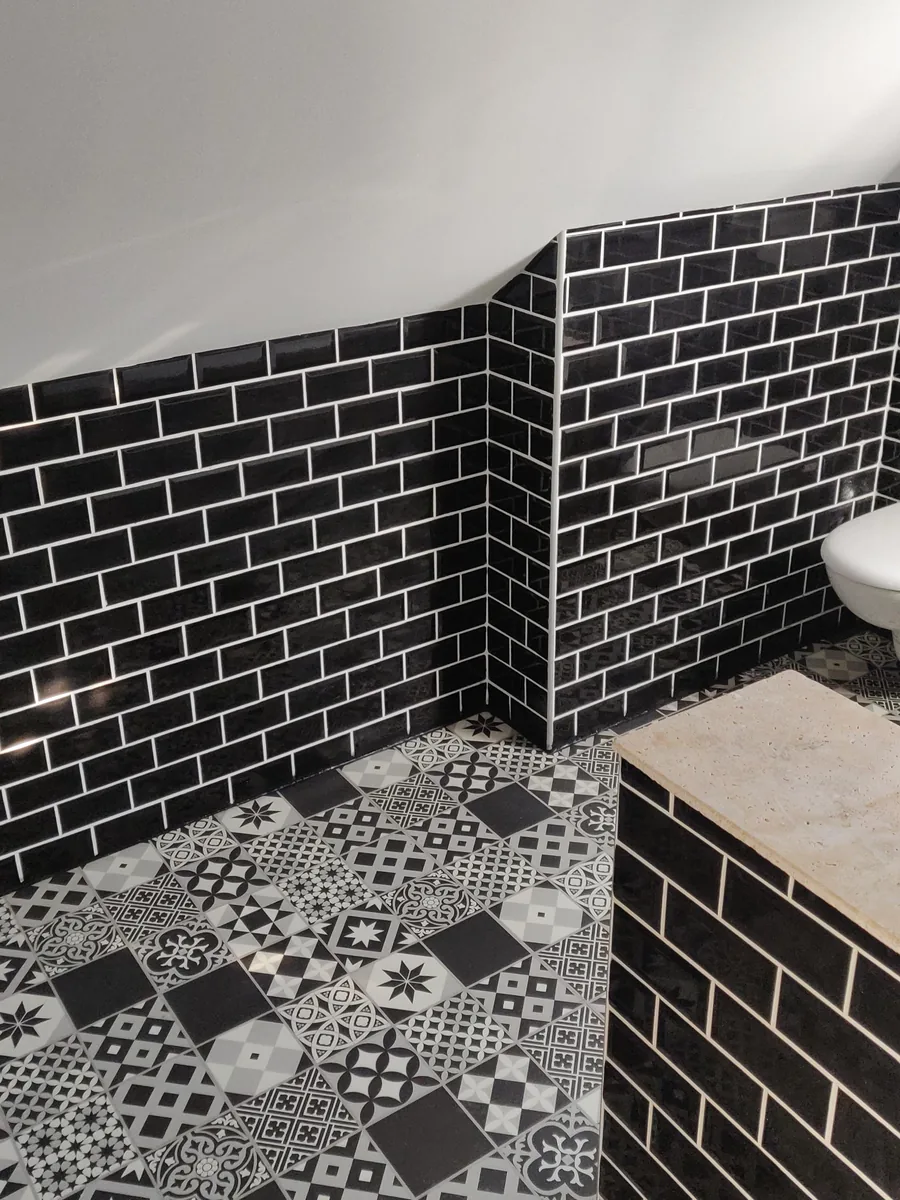 La seconde salle de bain, aménagée dans un ancien cagibi : faïence métro noire et sol en carreaux de ciment
