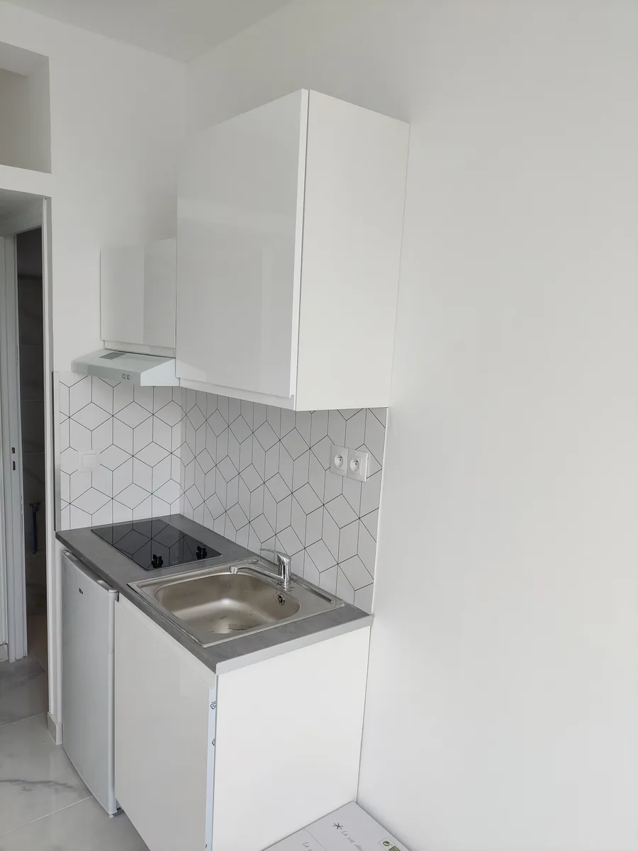 Kitchenette installée, crédence en faïence hexagonale blanche