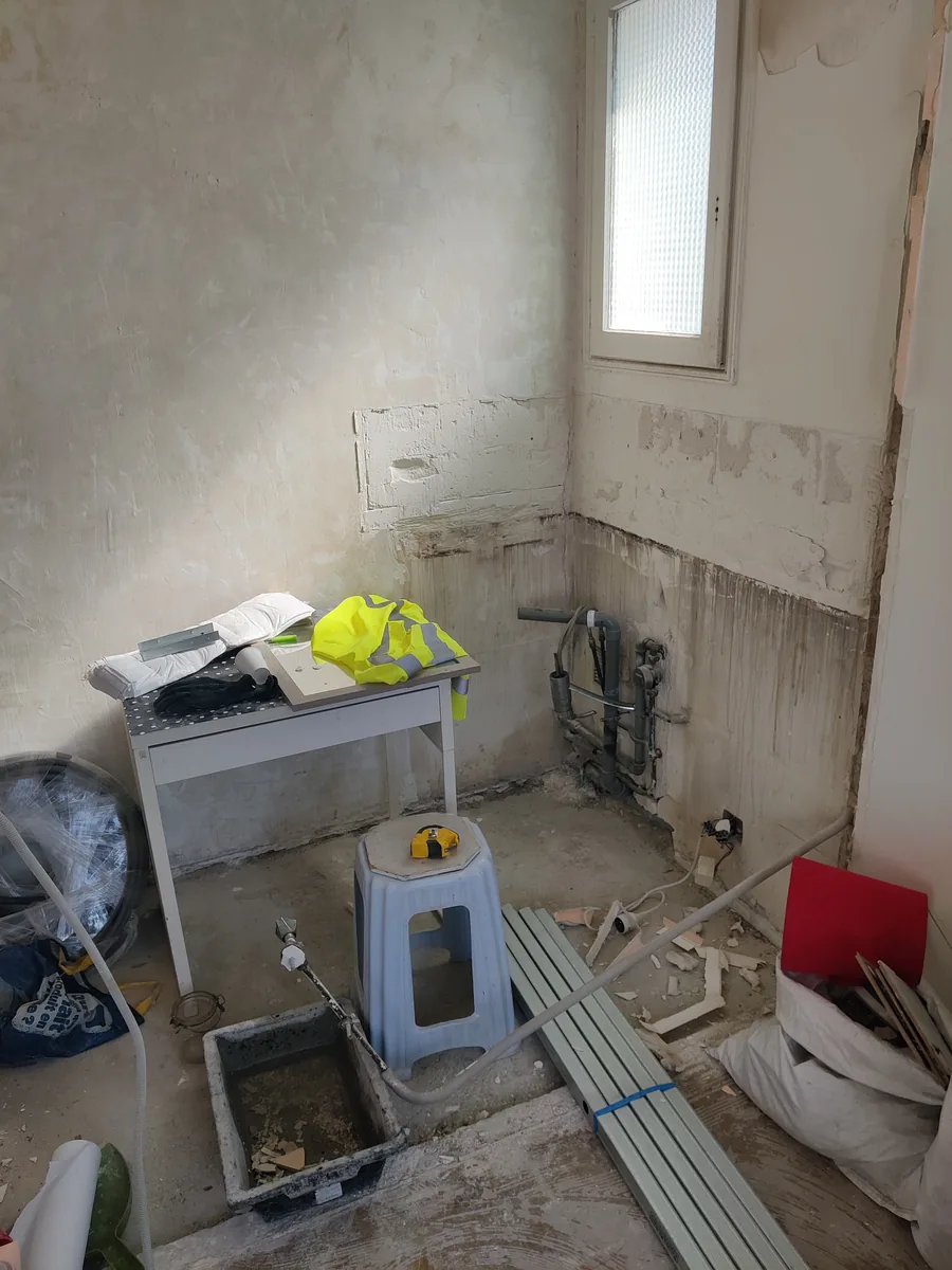 La salle d’eau avant travaux : sanitaires déposés, murs décroûtés